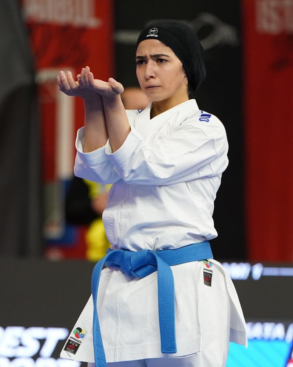 Jana Khamis holding a kata guard position on the competition mat.